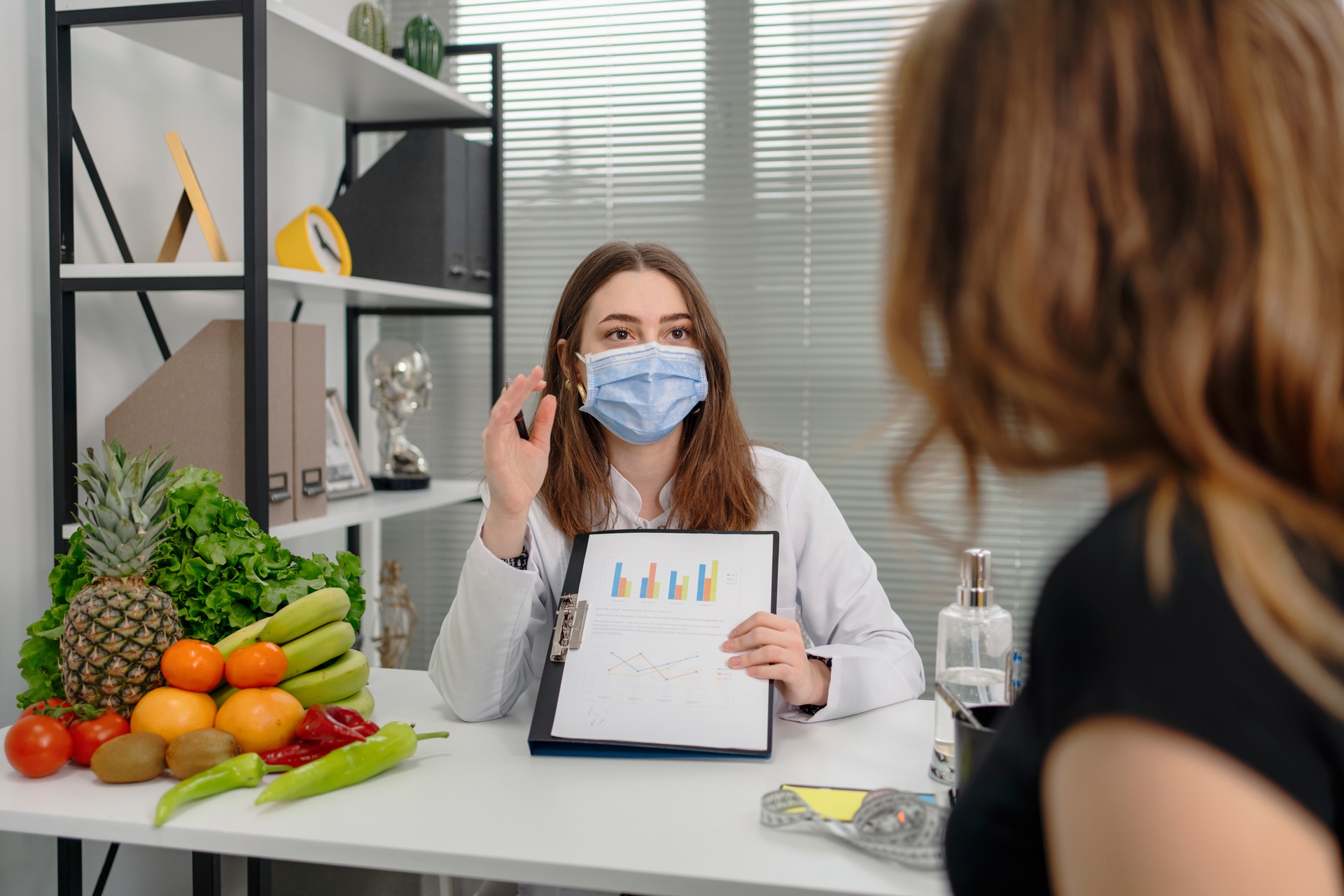 dietitian holding diet plan during consultation with patient in the office