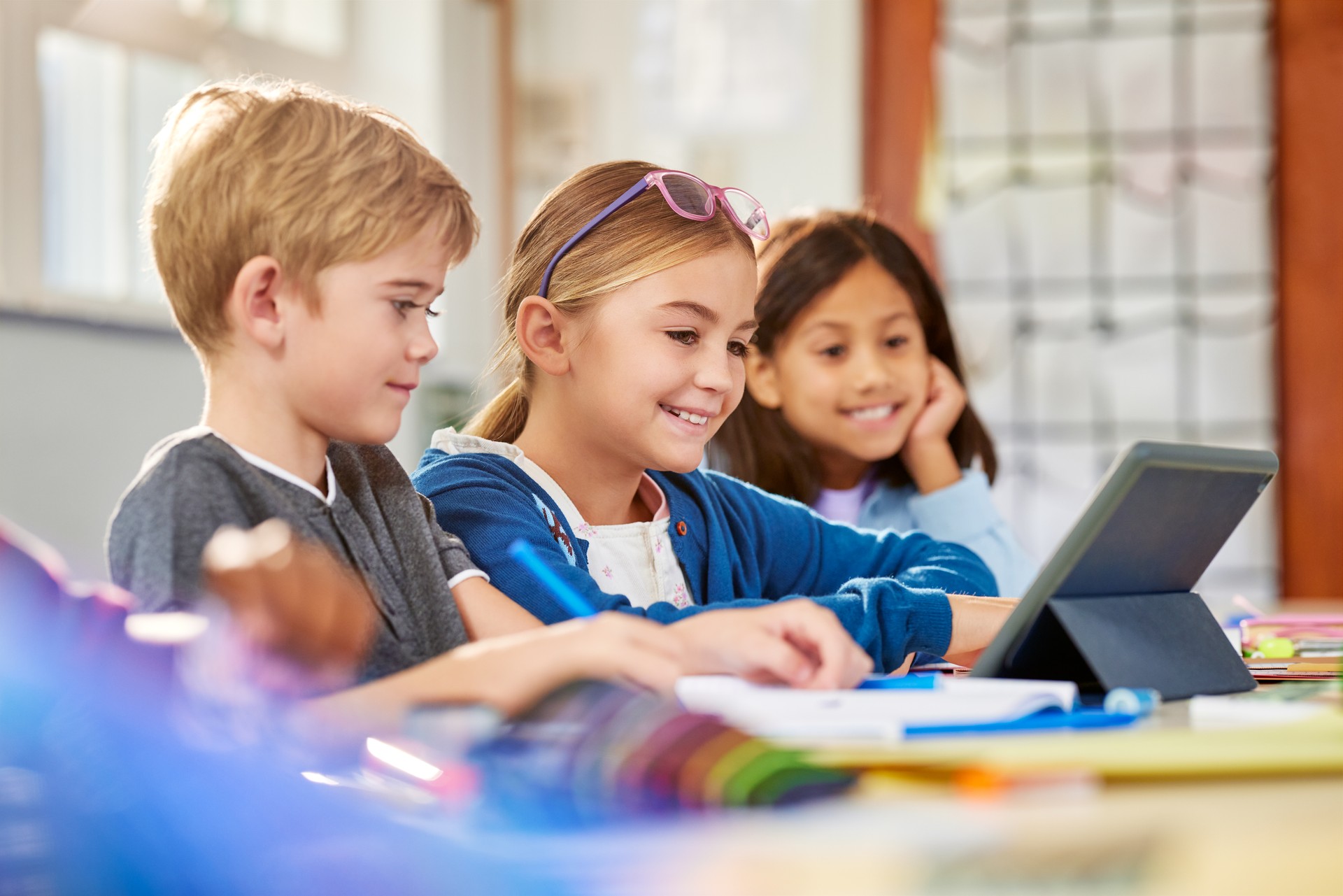 Multiethnic primary school students working on digital tablet